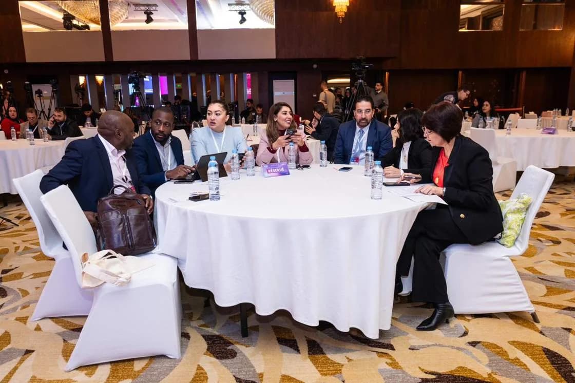 Delegates seated at round tables during a plenary session
