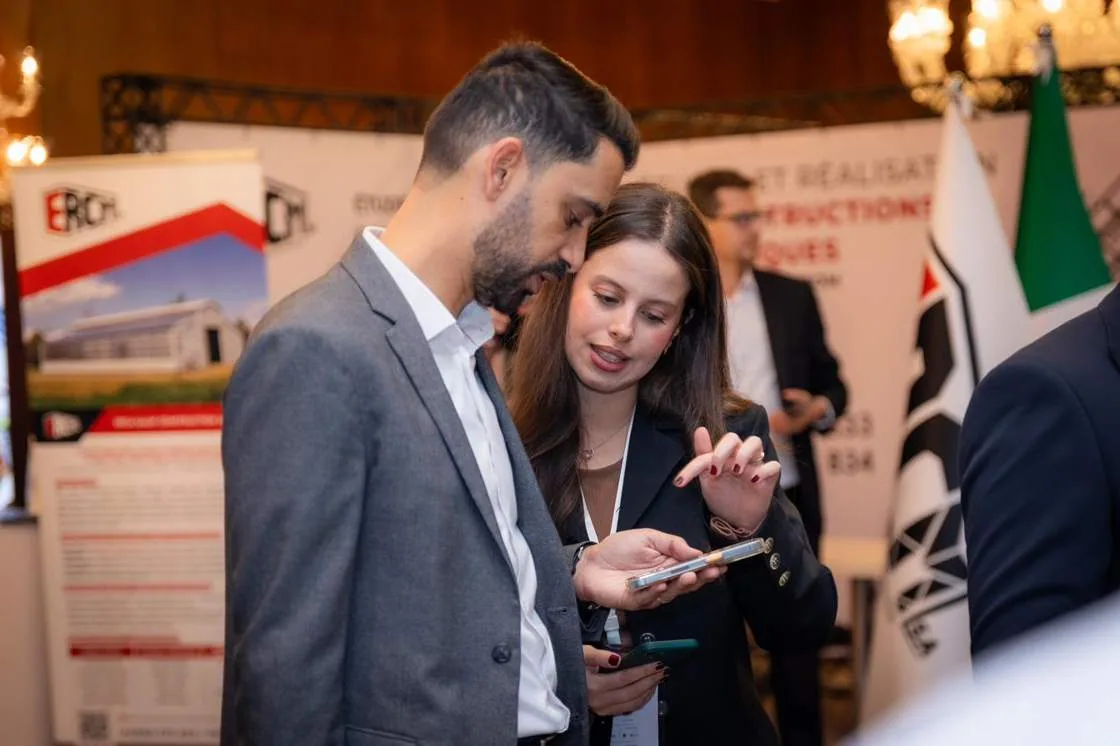 Two delegates comparing notes at an exhibitor stand
