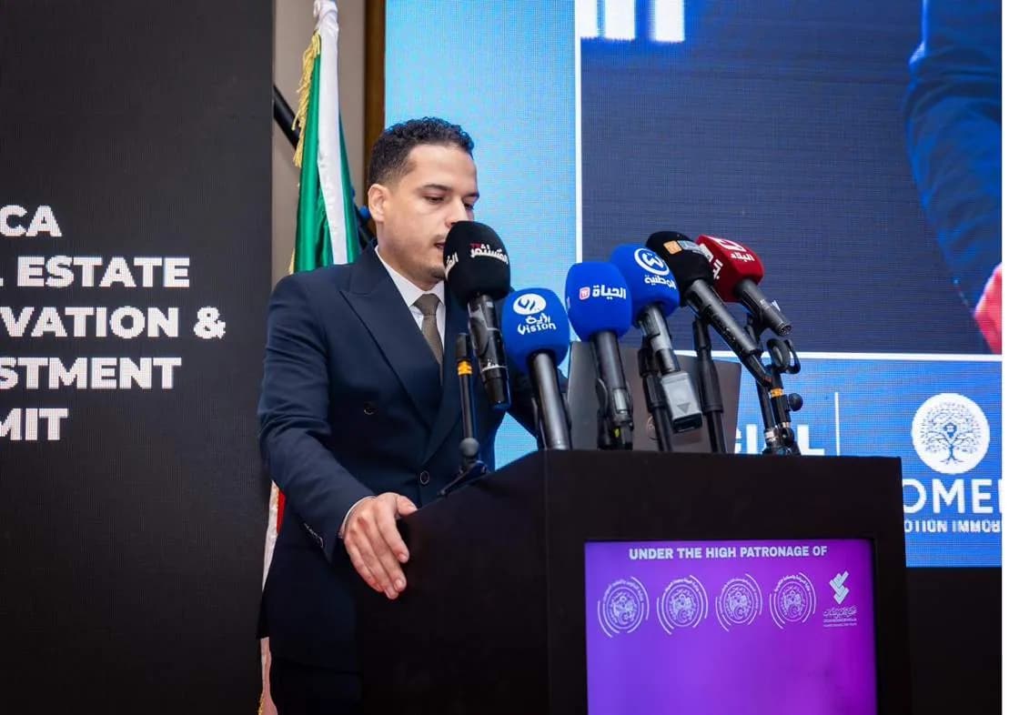 A speaker addressing the summit from the main podium
